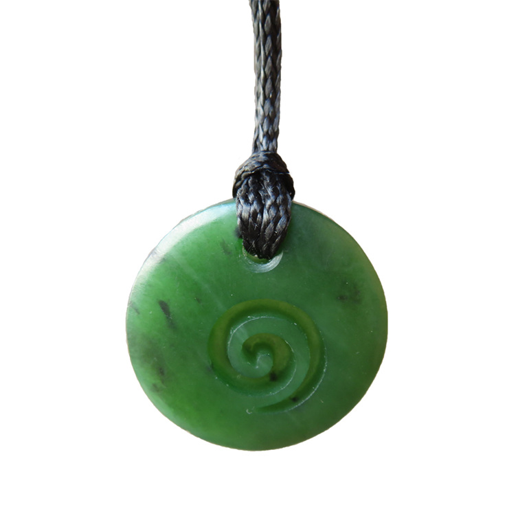 Round greenstone pendant with koru carved into it